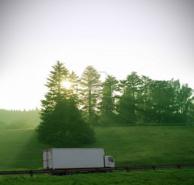 14334968-sun-and-forest-trees-shine-down-on-white-truck-delivery-with-motion-blur-on-highway-road